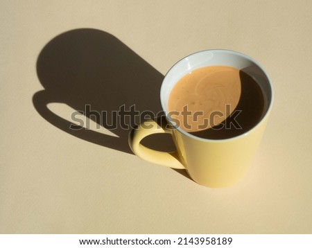Mug of cappuccino coffee on beige with harsh shadows in hard light. Minimalism natural colors.