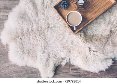 Mug With Coffee And Home Decor On Wooden Serving Tray On Sheep Skin Rug. Winter Weekend Concept, Top View 