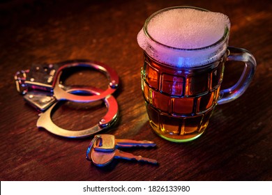 Mug of frothy beer with handcuffs and keys symbolizing drunk driving arrest