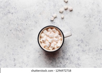 Mug With Hot Chocolate Or Cocoa With Marshmallow On White Concrete Table. Overhead View, Copy Space. Winter Background Or Greeting Card. Hygge Concept