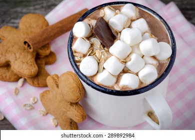 Mug with hot chocolate topped with mini marshmallows and gingerbread man cookies - Powered by Shutterstock