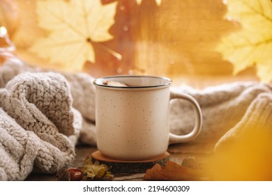  Mug of hot tea with apple and cinnamon on the autumn window. Autumn and fall cozy postcard 