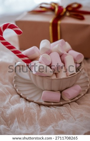 Mug with Marshmallows and Candy Cane with Gift Box in Background