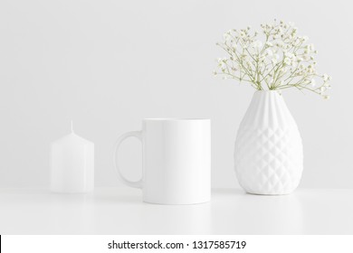 Mug Mockup With A Candle And A Gypsophila On A White Table.