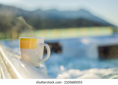 Mug with morning drink on the side of Hot tub hydromassage pool. Illuminated pool. Rest outside the city. Cottage with hydromassage pool