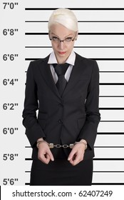 Mug Shot Of Young Business Woman Locked In Handcuffs.