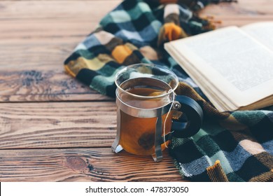 Mug With Tea Bag, Book And Plaid Winter Blanket On Vintage Wooden Table