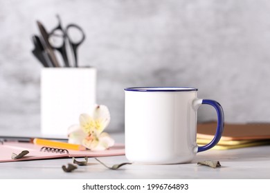 a mug of tea is on the table next to the items for the office