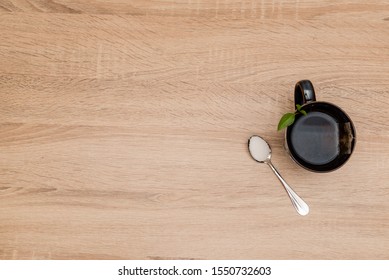 A Mug With Tea And A Spoon With Suger On A Wooden Table