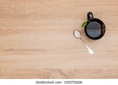 A Mug With Tea And A Spoon With Suger On A Wooden Table