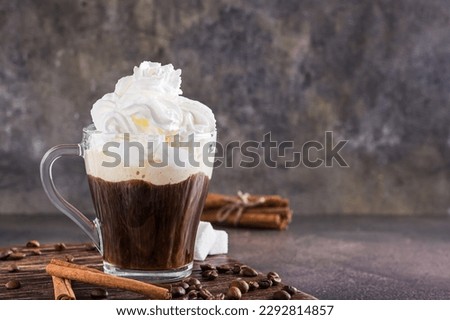 Mug of Viennese coffee with whipped cream and cinnamon on the table