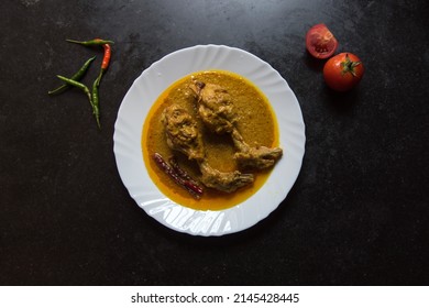 Mughal dish chicken chap served in a white plate on a dark background. Top view. - Shutterstock ID 2145428445