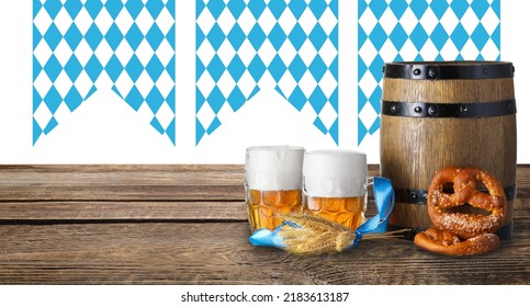 Mugs of fresh beer, pretzels and wooden barrel on table. Oktoberfest celebration