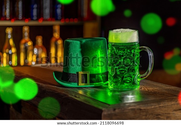 Mugs\
of green beer, ale on the bar counter. Holiday of Ireland on St.\
Patrick\'s Day in irish pub, bar. Festive Leprikon\'s green hat.\
National tradition of carnival celebrating March\
17.