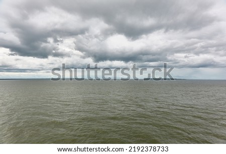 Muhu strait, Estonia, Baltic sea. Dramatic sky, storm clouds, water surface texture. Panoramic view. Nature, eco tourism, weather themes;