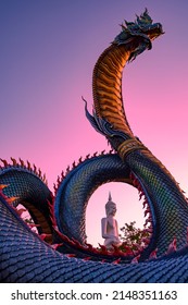 Mukdahan, Thailand - Apr 5 2022: King Naga Statue In Twilight Sky, See The White Buddha Image Through The Body Of The Naga At Wat Phu Manorom, A Major Tourists Attraction Of Mukdahan Amazing Thailand