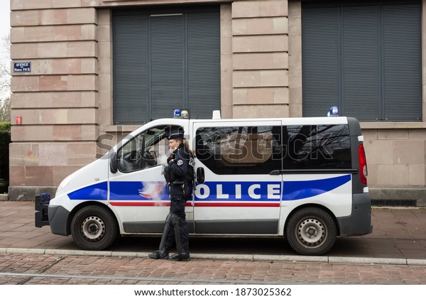 Mulhouse - France - 12 December 2020 -\
Portrait of police woman using a electronic cigarette standing near\
a national police van parked in the\
street