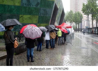 Mulhouse - France - 18 June 2020 - People Queue With Umbrella For The Covid-10 Free Testing In The Street By Rainy Day