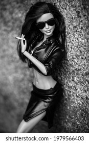 Mulhouse - France - 18 May 2021 - Portrait of brunette barbie doll wearing leather skirt and leather jacket with a cigarette in hand  in the street