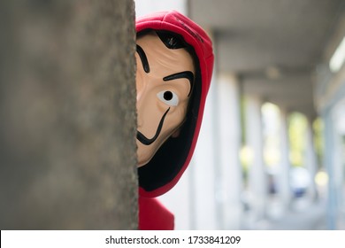 Mulhouse -  France - May 17 2020 : fan of the serie tv "La casa de papel' (paper house) traduction in english on Netflix standing with red sweat shirt costume and Salvador Dali mask in outdoor