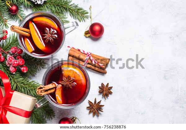 Mulled wine in glass mug with spices.\
Christmas hot drink on gray stone table. Top\
view.