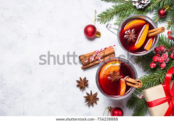 Mulled wine in glass mug with spices.\
Christmas hot drink on gray stone table. Top\
view.