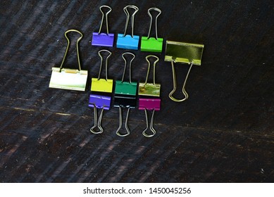 Multi Coloered Binder Clips On Barn Board