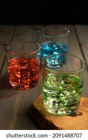 Multi Color Cocktails Or Drinks On Wood With Multi Color Objects Scattered On Table