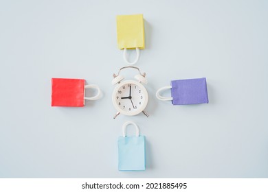 Multi Color Shopping Bags Around White Analog Alarm Clock With Copy Space, Shopping Time, Flash Sale Hour, Advertising Concept