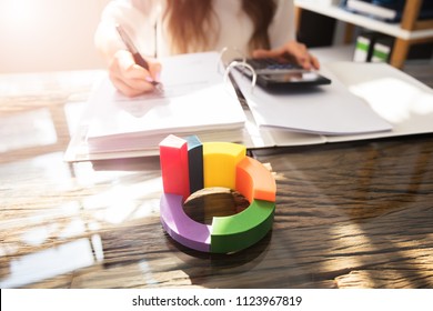 Multi Colored 3d Pie Chart In Front Of Businessperson Working At Workplace