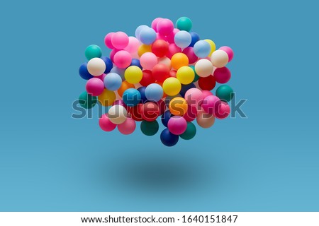 Multi colored balls levitation in mid air on blue background. 