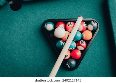 Multi colored billiard balls in the form of a triangle with numbers,a cue ball and a triangle on a pool table. billiard balls closeup.Toned.