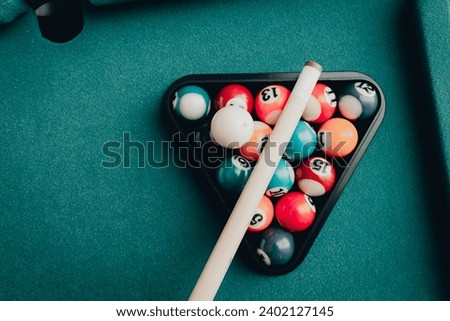 Multi colored billiard balls in the form of a triangle with numbers,a cue ball and a triangle on a pool table. billiard balls closeup.Toned.