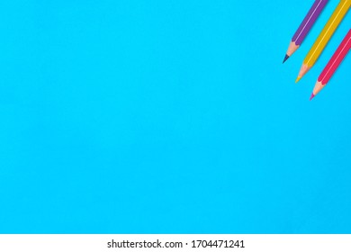 Multi colored crayons at light blue background