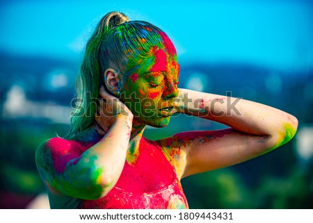 Multi colored face fully covered with bright holi paint. Colorful holi splash on body