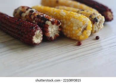 Multi Colored Indian Corn Made For Thanksgiving Decoration.  Southwestern Harvest Corn On White Wooden Table. Light Background. Side View. Close-up. Copy Space. Bokeh Effect