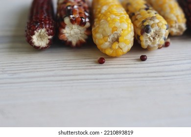 Multi Colored Indian Corn Made For Thanksgiving Decoration.  Southwestern Harvest Corn On White Wooden Table. Light Background. Side View. Close-up. Copy Space. Bokeh Effect