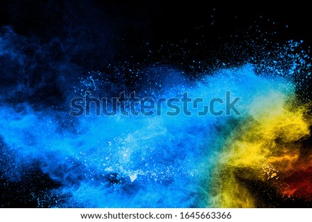 Multi colored particles explosion on black background.Colorful dust splash on dark background.