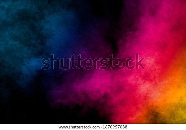 Multi colored particles\
explosion on black background.Colorful dust splash on dark\
background.