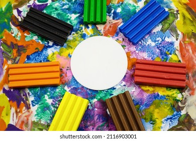 Multi Colored Rectangle Pieces Of Plasticine, Piece Of White Paper  In The Form Of A Circle Lie On A Cardboard With Plasticine Abstract Painting, Background