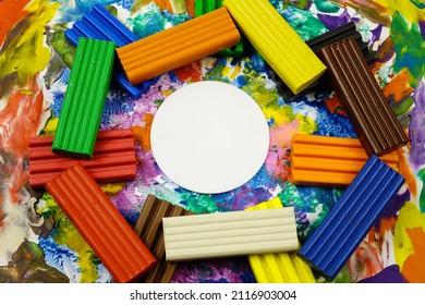 Multi Colored Rectangle Pieces Of Plasticine, Piece Of White Paper  In The Form Of A Circle Lie On A Cardboard With Plasticine Abstract Painting, Background