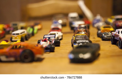 Multi Colored Toy Cars Lined Up On A Wooden Table Top