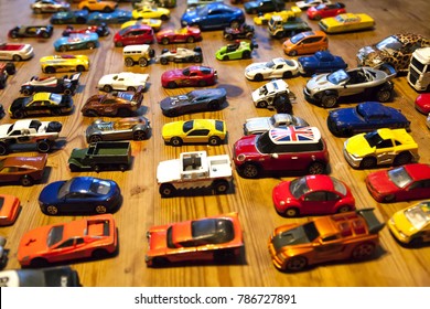 Multi Colored Toy Cars Lined Up On A Wooden Table Top