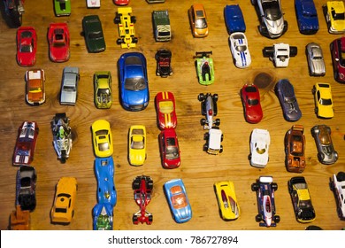 Multi Colored Toy Cars Lined Up On A Wooden Table Top