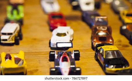 Multi Colored Toy Cars Lined Up On A Wooden Table Top