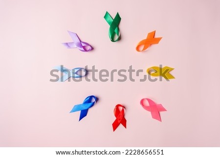 Multi colorful ribbons on pink background, cancer awareness, World cancer day, National cancer survivor day, world autism, supporting people living and illness, Prostate awareness concept.