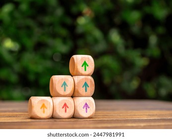 Multi Colors rise up arrows on wooden cube blocks stack, bar graph chart steps on green leaves background with copy space. Profit, benefit, income, market trends and business growth process concepts. - Powered by Shutterstock