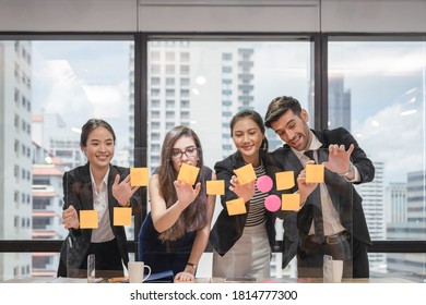 Multi Ethnic Business Team Brainstorming With Post It Note Paste Up On Conference Board In Coworking Space At Business District