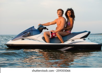Multi ethnic couple sitting on a jet ski