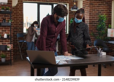 Multi Ethnic Diverse Company Business Employees Wearing Masks Against Covid Trying To Solve Financial Issues. Expectant Mother Analyzing Marketing Strategy Ideas While Having Clipboard In Hand.